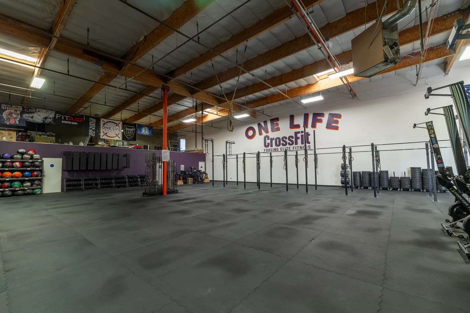 Spacious One Life CrossFit training floor, pull-up rig, and wall logo