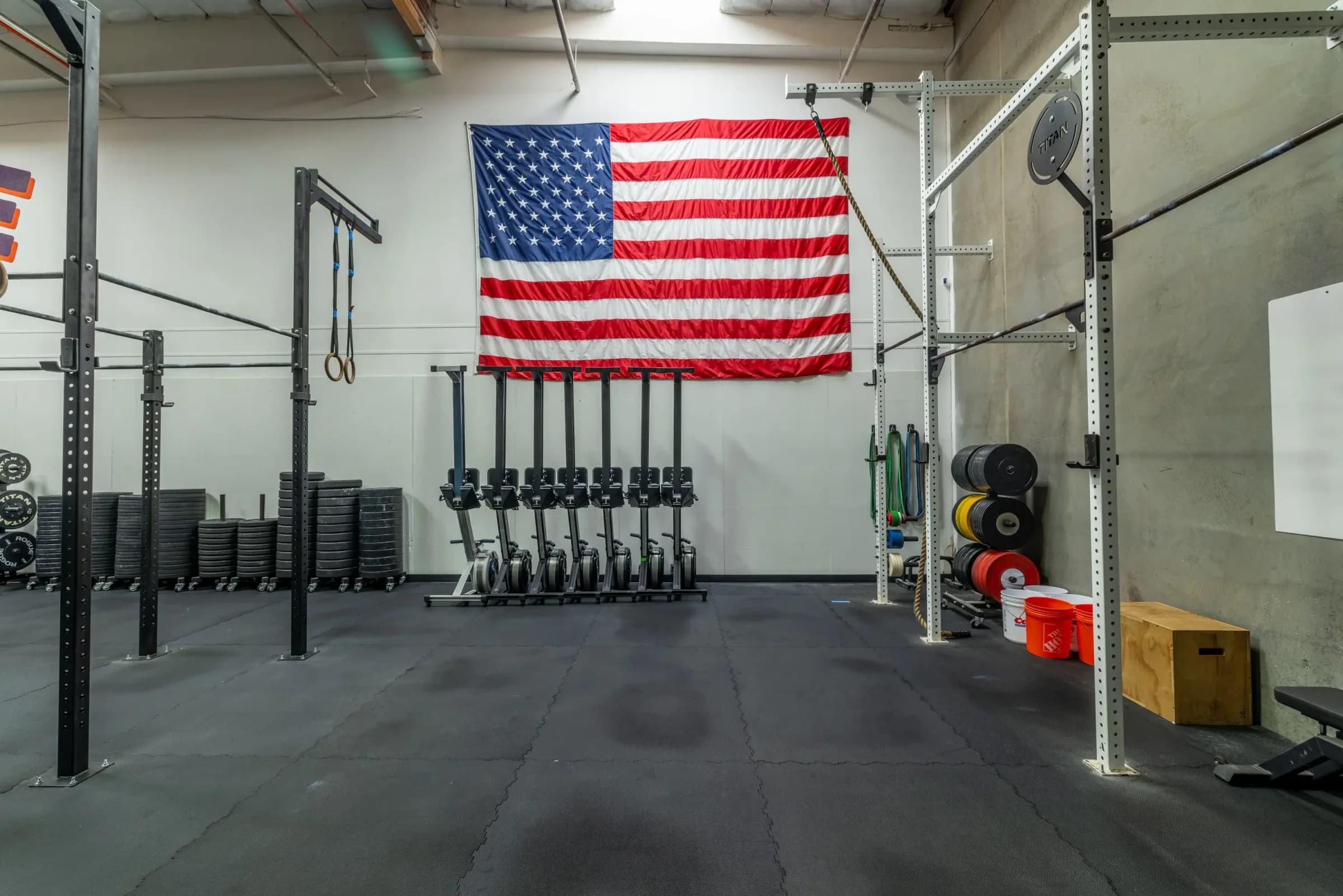One Life CrossFit training floor with SkiErgs, lifting platforms, and the American flag